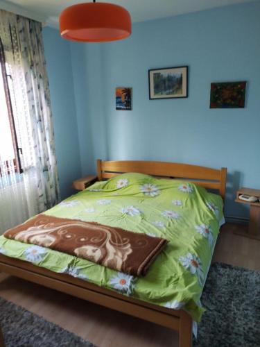 ein Schlafzimmer mit einem Bett mit einer grünen Bettdecke in der Unterkunft Vikendica Sibnica in Blace