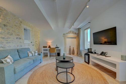 a living room with a blue couch and a table at Domaine de Privadière & Spa in Uzès