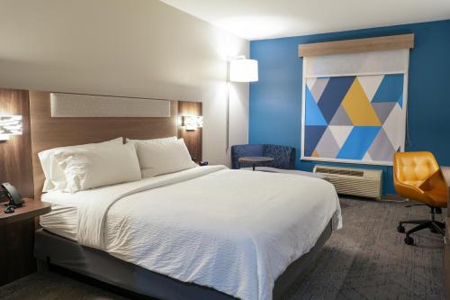 a hotel room with a bed and a chair at Holiday Inn Express Hotel & Suites Cedar Hill by IHG in Cedar Hill