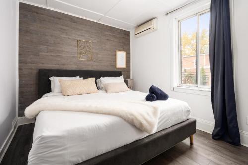 een slaapkamer met een groot bed en een groot raam bij Le Saint Christophe- Centre Ville in Montreal