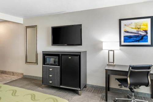 a hotel room with a desk and a flat screen tv at Quality Inn Kettleman City near Hwy 41 in Kettleman City