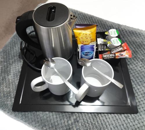 a black tray with two cups and a coffee maker at B&B At Forty Three in Vatsker