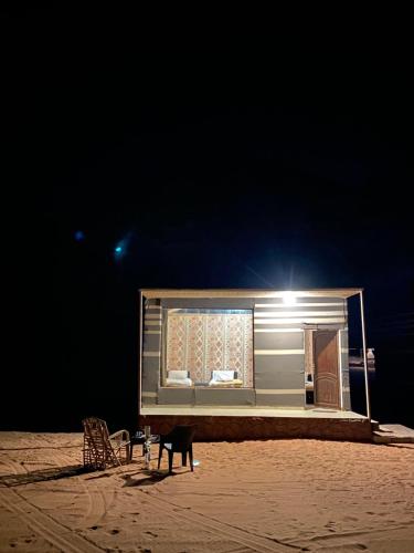 a building with a window on the beach at night at WADi RUM ALi CAMP in Wadi Rum