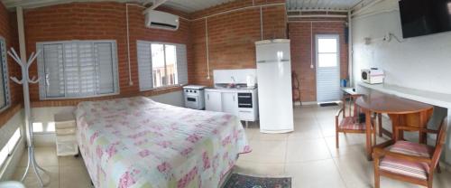 um quarto com uma cama e uma cozinha com um lavatório em Quarto aconchegante Barão Geraldo em Campinas