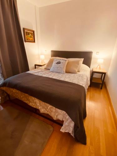 a bedroom with a large bed with two lamps at El Rincón del Marqués in Las Navas del Marqués