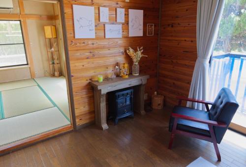 Zimmer mit einem Schreibtisch, einem Stuhl und einem Kamin in der Unterkunft ocean resort mint - Vacation STAY 62442v in Minamiboso