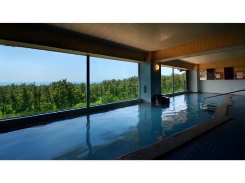 uma grande piscina com vista para as árvores em Yunohama Onsen Hanayubi Nihonkai - Vacation STAY 67572v em Tsuruoka