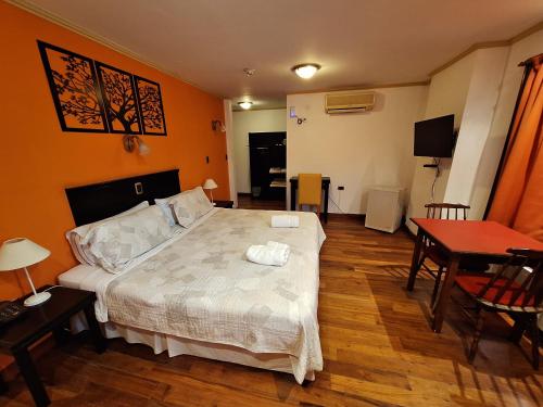 um quarto com uma cama, uma mesa e uma sala de jantar em Grand Hotel - Sierra De La Ventana em Sierra de la Ventana