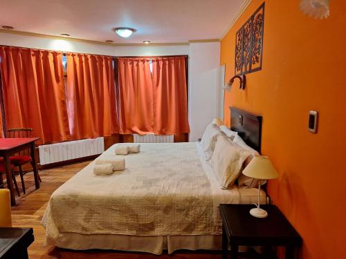 a bedroom with a large bed with orange walls at Grand Hotel - Sierra De La Ventana in Sierra de la Ventana