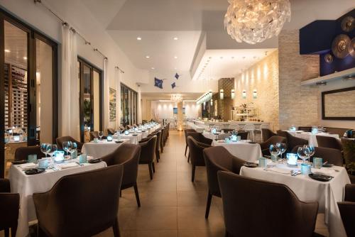a dining room with white tables and chairs at Wymara Resort & Villas in Grace Bay
