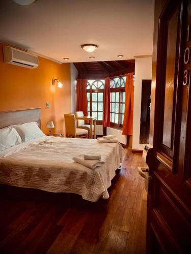 um quarto com uma cama, uma mesa e cadeiras em Grand Hotel - Sierra De La Ventana em Sierra de la Ventana