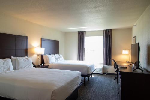a hotel room with two beds and a window at Cobblestone Inn & Suites -Springfield in Springfield