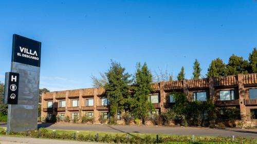 a building with a sign in front of it at Hotel Villa el Descanso in Curicó