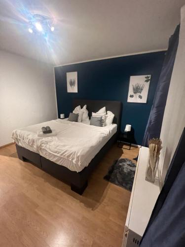 1 dormitorio con 1 cama con pared azul en Mondschein Appartement+Netflix+zentral, en Bochum