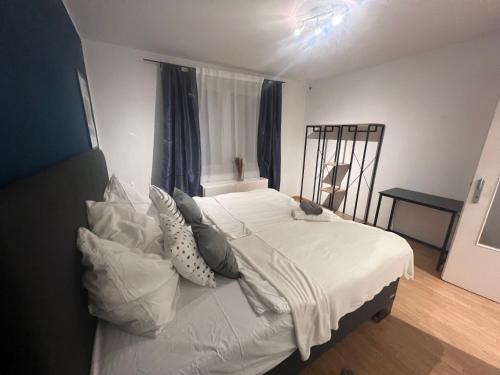 1 dormitorio con 1 cama con sábanas y almohadas blancas en Mondschein Appartement+Netflix+zentral, en Bochum