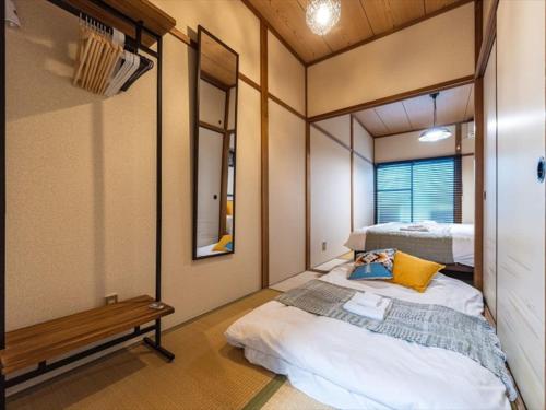 a small room with a bed and a mirror at Chachamaru Osaka Castle Park - Vacation STAY 15422 in Osaka
