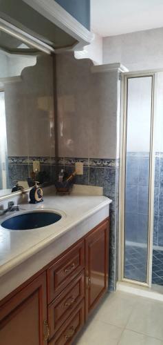 een badkamer met een wastafel en een grote spiegel bij hermosa habitacion en casa residencial in Guadalajara