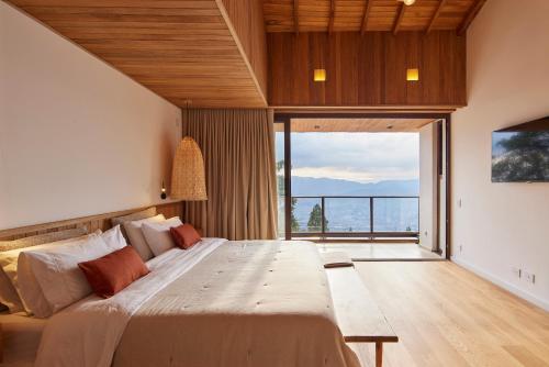 a bedroom with a large bed and a large window at Hilltop Enchanting Villa with Stunning Views & Jacuzzi in Medellín