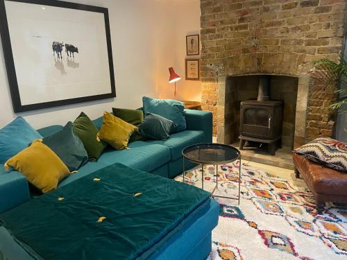 a living room with a blue couch and a fireplace at Beautiful London Victorian house, sleeps 12 in London