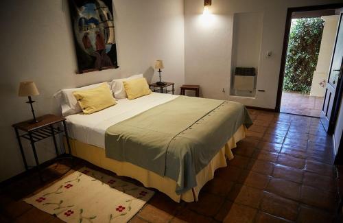um quarto com uma cama grande e almofadas amarelas em Viñas De Cafayate Wine Resort em Cafayate