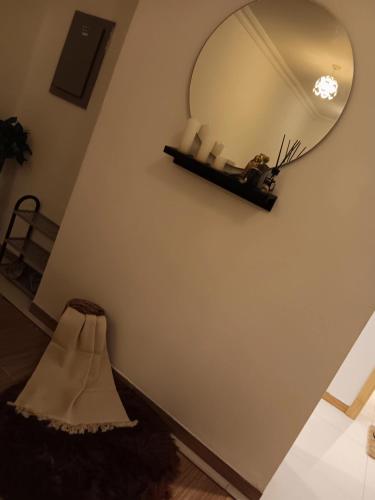een spiegel aan een muur naast een plank aan een muur bij Kayan apartment1 in Fatḩ Āl Bū Sa‘īd