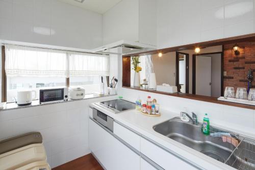 a kitchen with a sink and a microwave at Wind Henza - Vacation STAY 73155v in Uruma