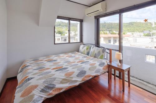 a bedroom with a bed and a window at Wind Henza - Vacation STAY 73155v in Uruma