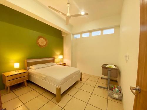a bedroom with a bed and a green wall at Edificio Teocalli, Bacocho Puerto Escondido in Puerto Escondido