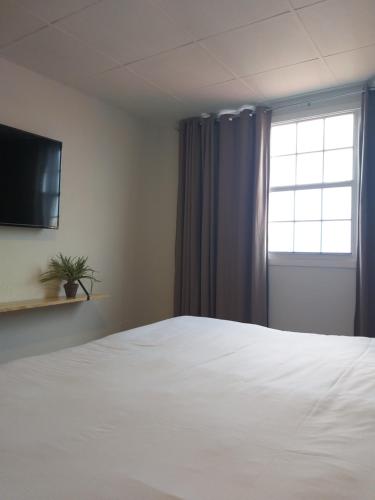 a bedroom with a white bed and a window at San Marco Hotel Curacao & Casino in Willemstad