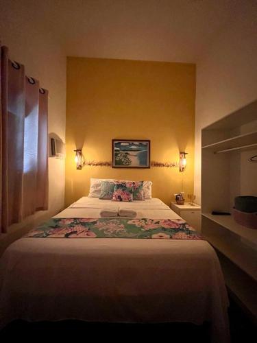 a bedroom with a large bed with flowers on it at Pousada Dona Felicidade Carneiros in Tamandaré