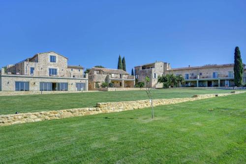 un árbol en un campo frente a un edificio en Domaine de Privadière, en Garrigues-et-Sainte-Eulalie