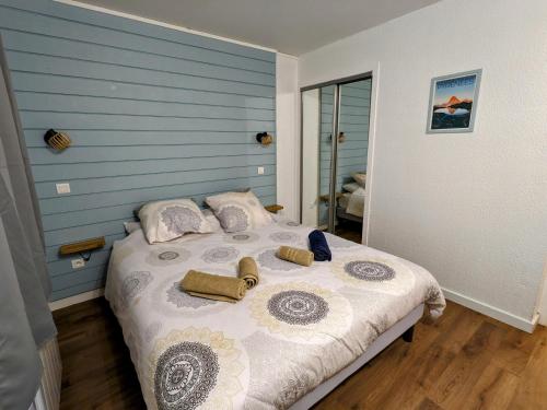 Appartement 4 personnes et jardin في Bielle: غرفة نوم بسرير مع جدار ازرق