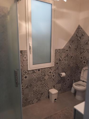 uma casa de banho com um espelho e um WC em Casa Vacanze "O Timpune" em Petrosino