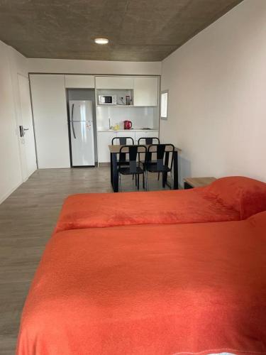 Zimmer mit einem Bett und einer Küche mit einem Tisch und Stühlen in der Unterkunft monoambiente rosario zona pichincha in Rosario