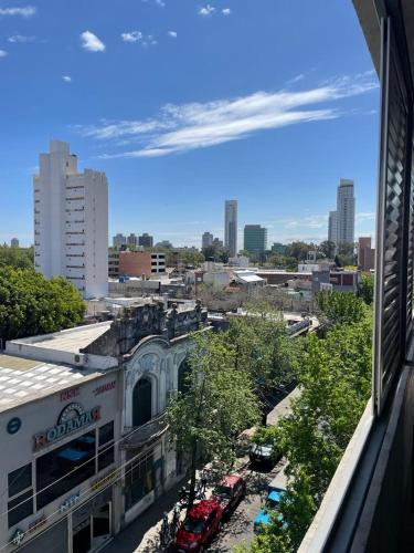 Blick auf eine Stadt mit vor einem Gebäude geparkten Autos in der Unterkunft monoambiente rosario zona pichincha in Rosario