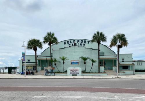 a building with palm trees in front of it at Lovely vacation home 1 block from beach & downtown Gulfport in St. Petersburg