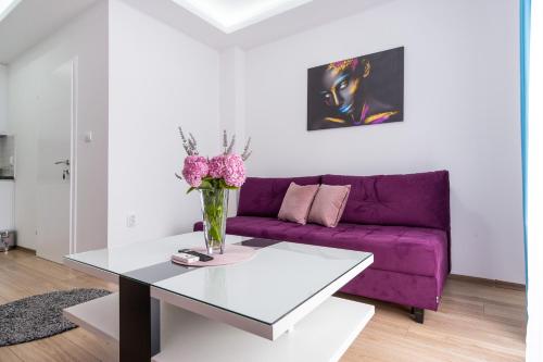 a living room with a purple couch and a table at Apartments Sweet Dreams in Trebinje