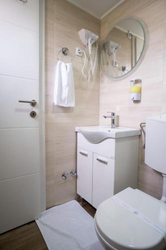 a bathroom with a toilet and a sink and a mirror at Apartments Sweet Dreams in Trebinje