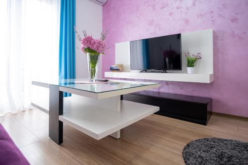 a living room with a glass table with flowers on it at Apartments Sweet Dreams in Trebinje
