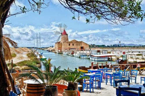 un puerto deportivo con mesas y sillas y un molino de viento en Casa Vacanze "O Timpune", en Petrosino