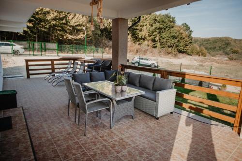 d'une terrasse avec une table, des chaises et un canapé. dans l'établissement Pensiunea Cristina, 