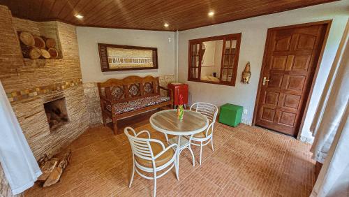 a living room with a table and chairs and a fireplace at POUSADA DAS ORQUIDEAS20 in Guapimirim