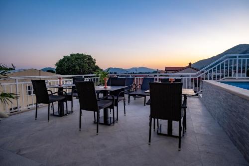 a patio with tables and chairs on a balcony at Apartments Sweet Dreams in Trebinje