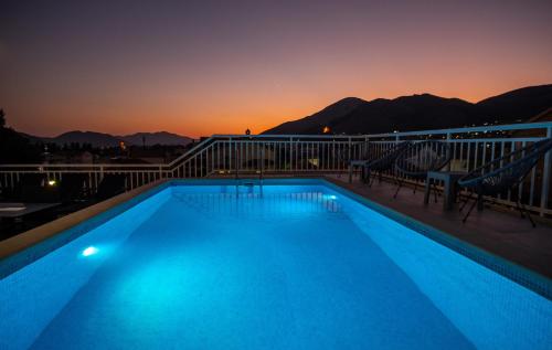a swimming pool at night with mountains in the background at Apartments Sweet Dreams in Trebinje