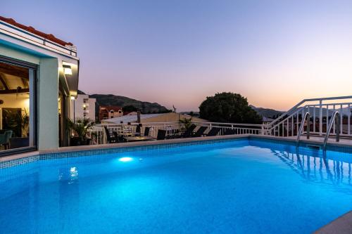 a large blue swimming pool next to a building at Apartments Sweet Dreams in Trebinje