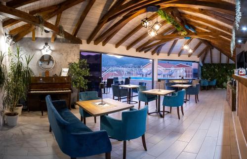 a restaurant with tables and chairs and a piano at Apartments Sweet Dreams in Trebinje