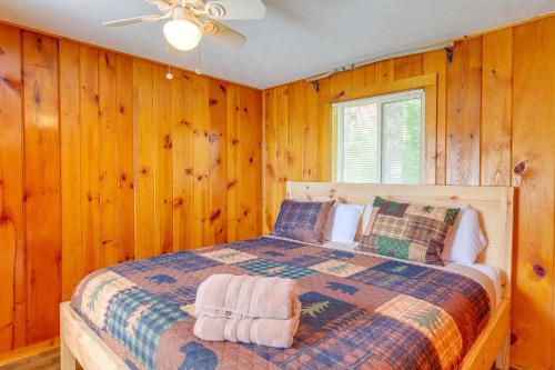 um quarto com uma cama com paredes de madeira em Kalkaska Retreat Private Hot Tub, Dock, Fireplace em Kalkaska