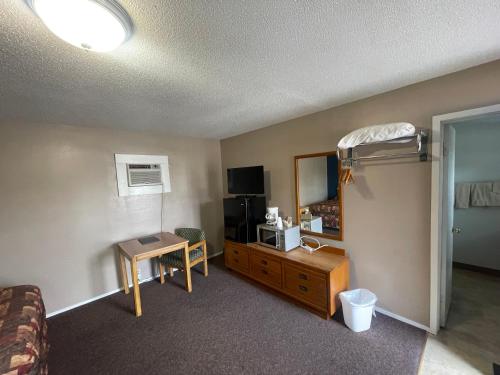 - une chambre d'hôtel avec un lit et un bureau dans l'établissement The Village Motel, à Steamboat Rock