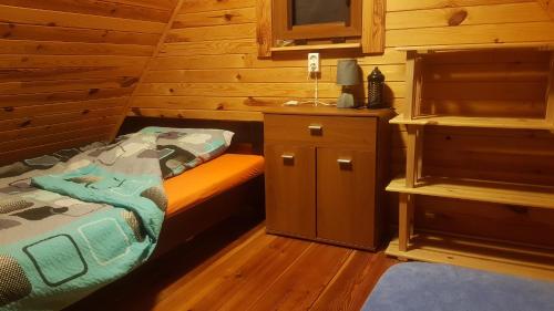 a bedroom with a bed in a wooden cabin at Domek Letniskowy Krejwince in Krejwińce