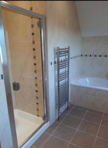 a bathroom with a shower and a bath tub at The Lake House in Drumshanbo